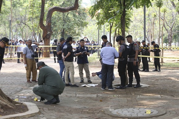 Police investigators inspect the site of an explosion in Jakarta, Indonesia, Tuesday, Dec. 3, 2019. An explosion from a smoke grenade occurred Tuesday near the presidential palace in Indonesia's ...