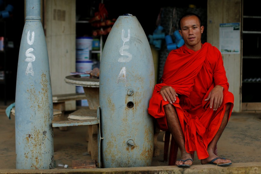 A Buddhist monk poses next to unexploded bombs dropped by the U.S. Air Force planes during the Vietnam War, in Xieng Khouang in Laos September 3, 2016. REUTERS/Jorge Silva SEARCH &quot;LAOS BOMBS&quot ...