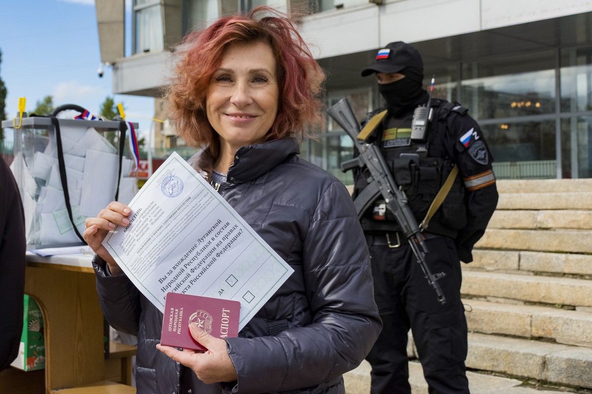 FILE - A woman shows her ballot to journalists prior to voting in a referendum in Luhansk, Luhansk People's Republic controlled by Russia-backed separatists, eastern Ukraine, Saturday, Sept. 24,  ...