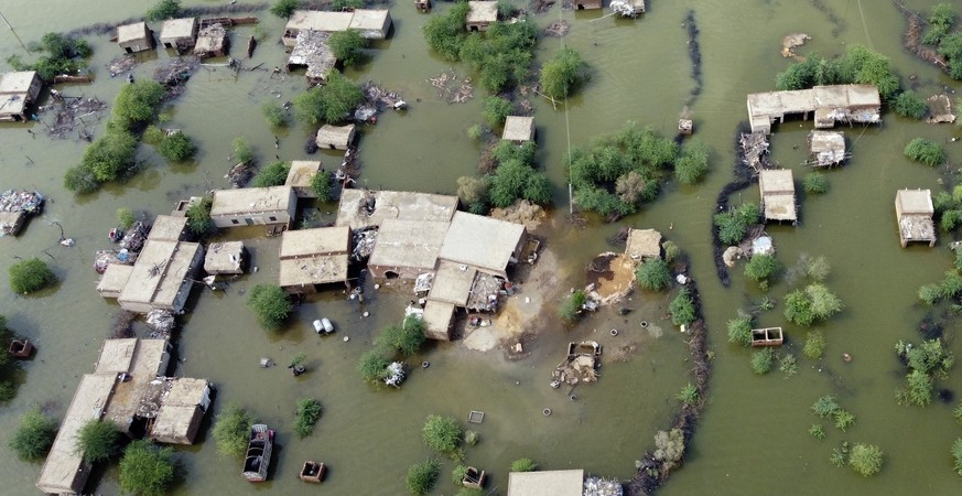 FILE - Homes are surrounded by floodwaters in Sohbat Pur city, a district of Pakistan&#039;s southwestern Baluchistan province, Aug. 30, 2022. This past year has seen a horrific flood that submerged o ...