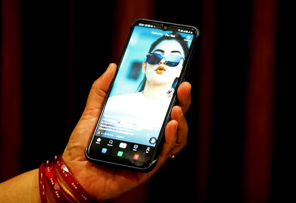 epa08532051 (FILE) - A woman watches a short video on the Chinese video-sharing app TikTok on her smartphone, in Bhopal, India, 29 June 2020 (reissued 07 July 2020). US State Secretary Pompeo on 06 Ju ...