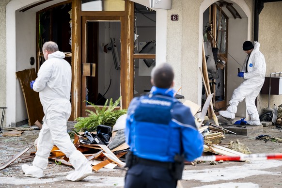 Des membres de la police scientifique de la Gendarmerie vaudoise, inspectent l&#039;explosion du bancomat de la Raiffeisen apres un braquage le jeudi 2 fevrier 2023 a Biere. (KEYSTONE/Jean-Christophe  ...