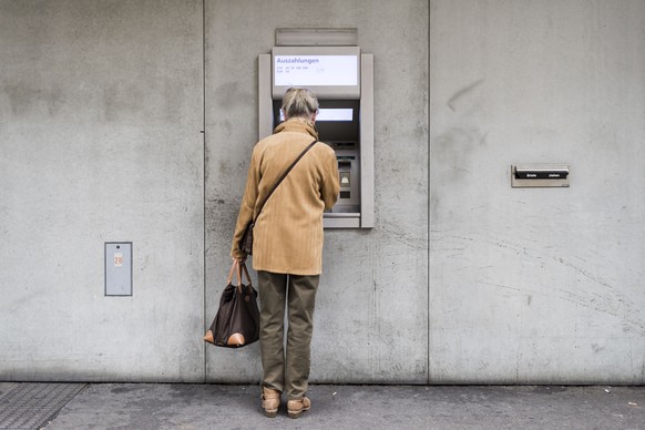 ARCHIVBILD ZUR PRAESENTATION DER RENTENREFORM DURCH DEN BUNDESRAT, AM DONNERSTAG, 28. JUNI 2018 - An elderly woman withdraws money from a cash dispenser, photographed in Zurich, Switzerland, on Septem ...