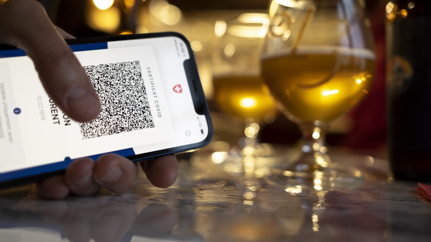 Une personne tient dans sa main un smartphone avec l'application Certifact Covid suisse dans un restaurant ce vendredi 10 septembre 2021 a Rances dans le canton de Vaud. Des ce lundi 13 septembre, il  ...