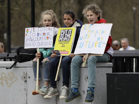 Auch die Kinder gehen mit: Trio mit Manifesten vor dem Umzug in London.