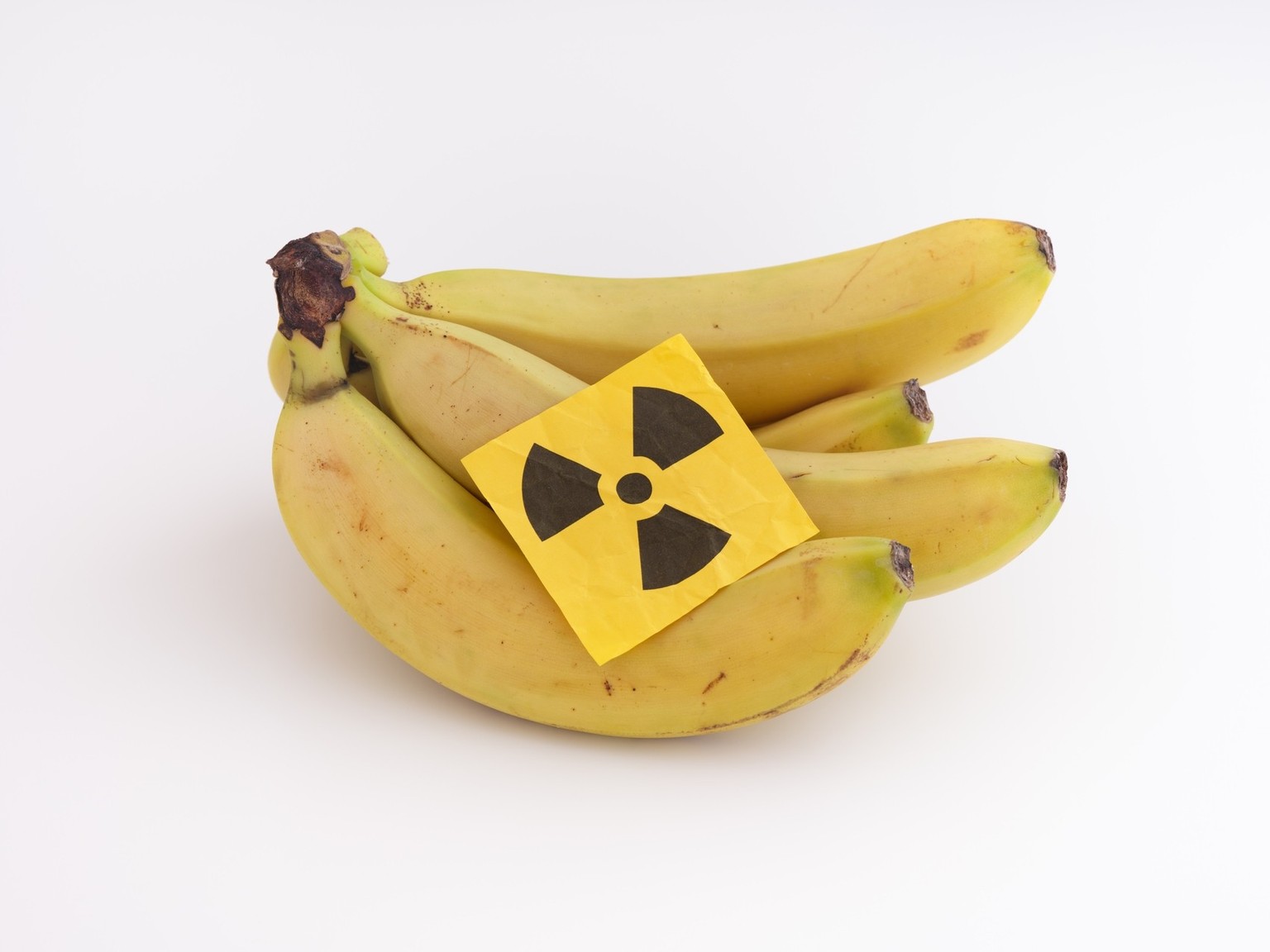 A bunch of bananas with a radiation warning sign on them. Close up. xkwx banana, bunch, diet, food, contamination, radiation sign, radiation symbol, radioactive, radiation, concept, nuclear, plutonium ...