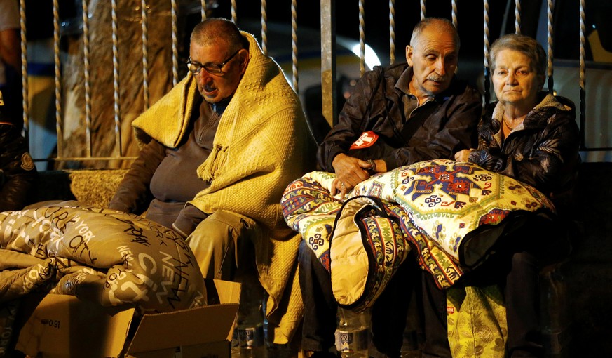 People cover themselves with blankets as they prepare to spend the night in the open following an earthquake in Amatrice, central Italy, August 24, 2016. REUTERS/Stefano Rellandini