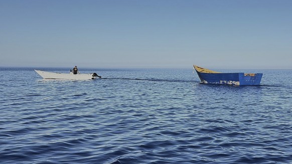A boat used by migrants to cross the Mediterranean Sea is towed from Tripiti beach to the Karave the port of Gavdos, Greece, on Monday, July 7, 2025 after hundreds were rescued near the island and the ...