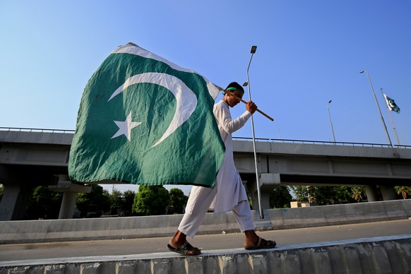epa09413412 A Pakistani boy holds a national flag during Independence Day celebrations in Peshawar, Pakistan, 14 August 2021. Pakistan celebrates its 74th Independence Day on 14 August since it became ...