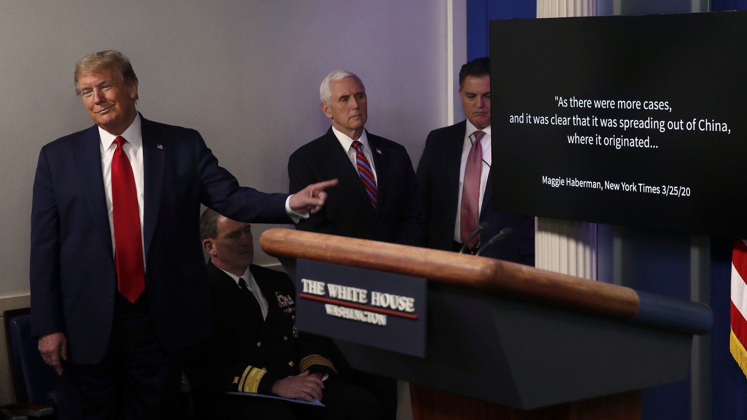 President Donald Trump points as he watches as a White House produced video plays during a briefing about the coronavirus in the James Brady Press Briefing Room at the White House, Monday, April 13, 2 ...