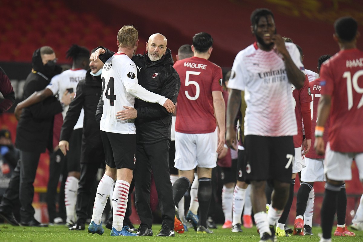 epa09068563 Milan's head coach Stefano Pioli (C) celebrates with Simon Kjaer (L) after the UEFA Europa League round of 16, first leg soccer match between Manchester United and AC Milan in Manches ...