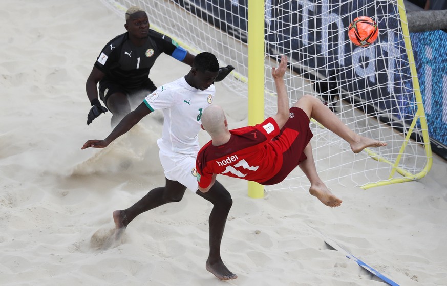 epa09435343 Glenn Hodel (front) of Switzerland in action against Pape Mar Boye (C) and goalkeeper Al Seyni Ndiaye (L) of Senegal during the FIFA Beach Soccer World Cup 2021 match for third place betwe ...