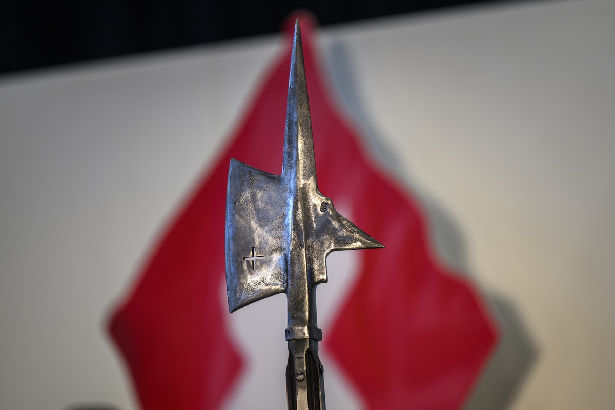 Eine Hellebarde vor einer Schweizer Flagge waehrend der Delegiertenversammlung der Schweizerischen Volkspartei SVP, fotografiert am Samstag, 25. Oktober 2025 in Wimmis. (KEYSTONE/Christian Beutler)
