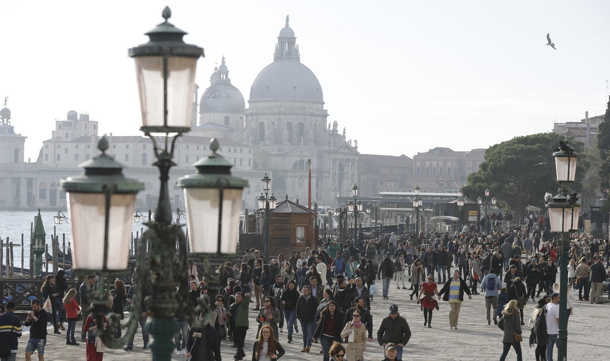 Tourists stroll in downtown Venice, Italy, Saturday, Nov. 12, 2016. Since 1951, Venice's population has steadily shrunk from 175,000 to some 55,000. Several factors are blamed, including high pri ...