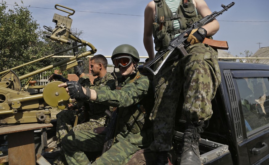 Pro-Russian rebels sit in their car with a heavy machine gun in Donetsk, eastern Ukraine, Sunday, Sept. 7, 2014. Strong explosions were heard early Sunday on the outskirts of the main rebel-held city  ...