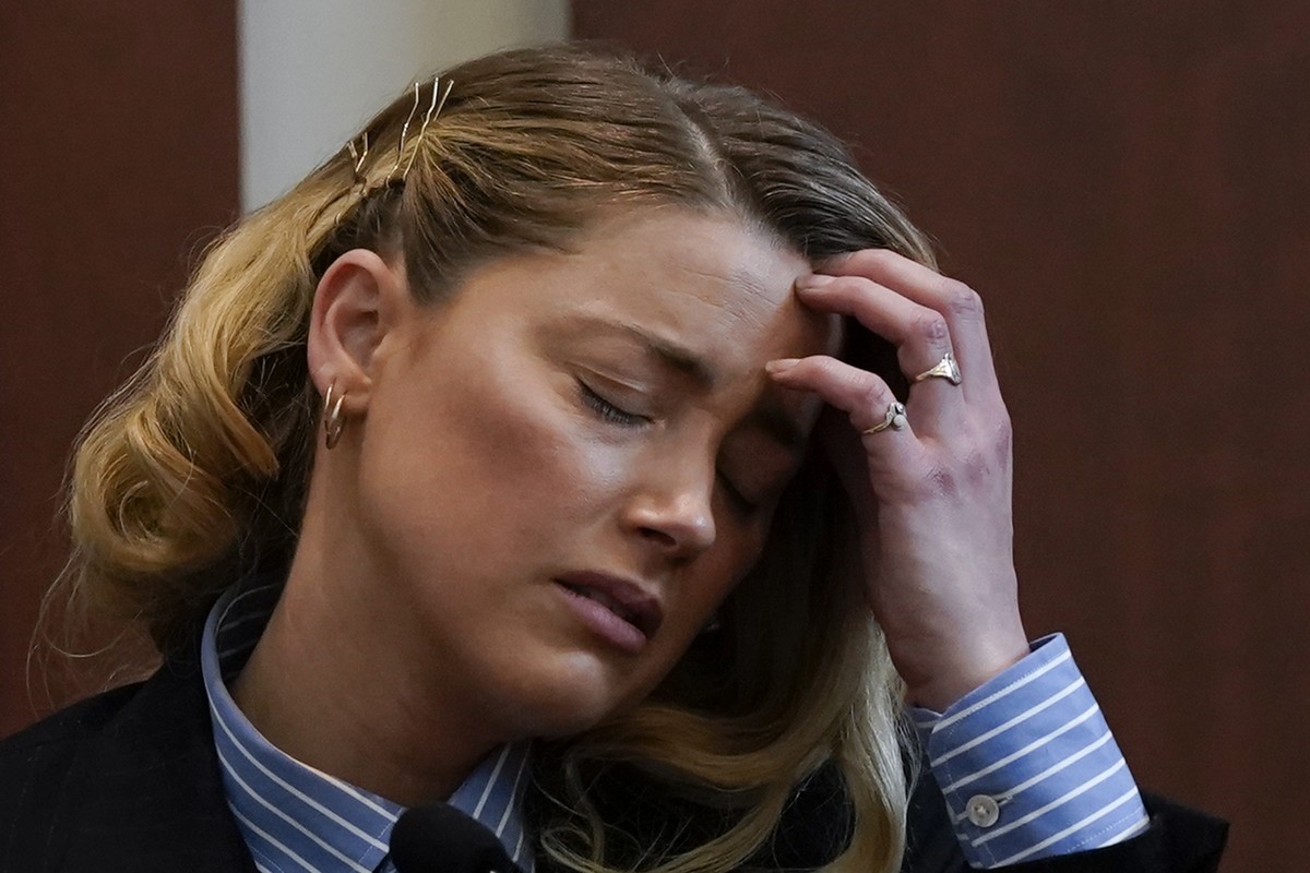 epa09927749 US actress Amber Heard reacts as she testifies during the Depp v Heard defamation case at Fairfax County Circuit Court, in Fairfax, Virginia, USA, 04 May 2022 (issued 05 May 2022). US acto ...