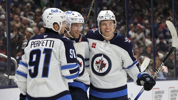 Winnipeg Jets forward Nikolaj Ehlers, center, celebrates his second goal against the Columbus Blue Jackets with teammate forward Cole Perfetti, left, and forward Vladislav Namestnikov during the first ...