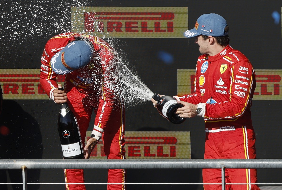 epaselect epa11672064 Charles Leclerc of Monaco (R), first place, douses Team Ferrari teammate, Carlos Sainz Jr. of Spain (L), second place with sparkling wine on the awards podium at the Formula One  ...