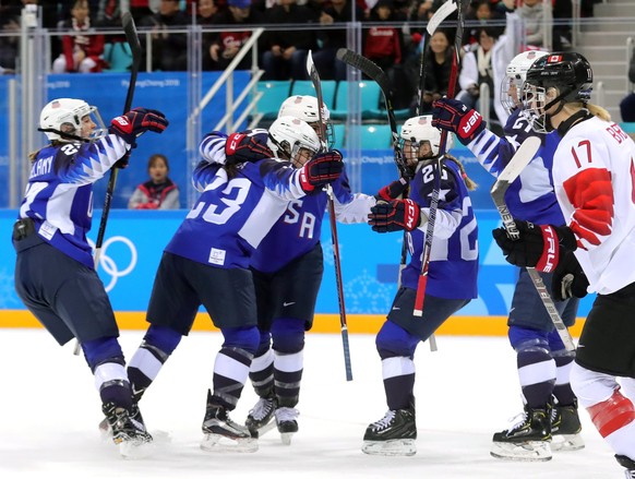 epa06552355 Hilary Knight of the USA (2-R, partially obsscured) celebrates with teammates after scoring the opening goal during the Women&#039;s Ice Hockey Gold medal match between Canada and the USA  ...