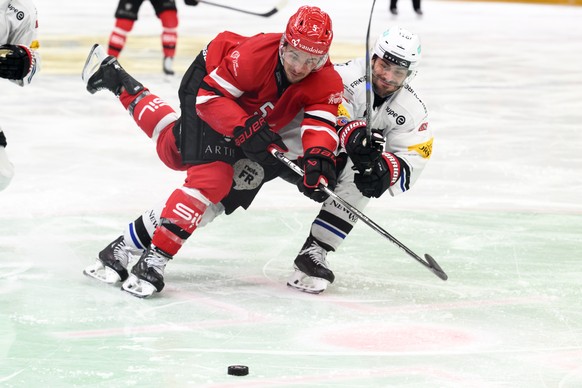 Gavin Bayreuther (LHC), gauche, lutte pour le puck avec Raphael Diaz (HCFG), droite, lors du 3e match de play-off des demi-finales du championnat suisse de hockey sur glace de National League entre La ...