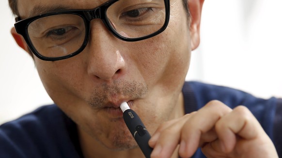 A customer tries a Philip Morris&#039; &quot;iQOS&quot; smokeless tobacco e-cigarette at an iQOS store in Tokyo, Japan, March 3, 2016. REUTERS/Toru Hanai