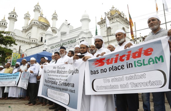 epa07529110 Sri Lankan Muslims hold posters as they stand together in solidarity for the people killed in the series of blasts at Dawatagaha mosque in Colombo, Sri Lanka, 26 April 2019. According to r ...