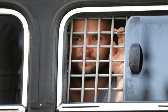 A detained protester looks out of a police bus window prior to an unsanctioned rally in the center of Moscow, Russia, Saturday, July 27, 2019. Police have established a heavy presence at the Moscow ma ...