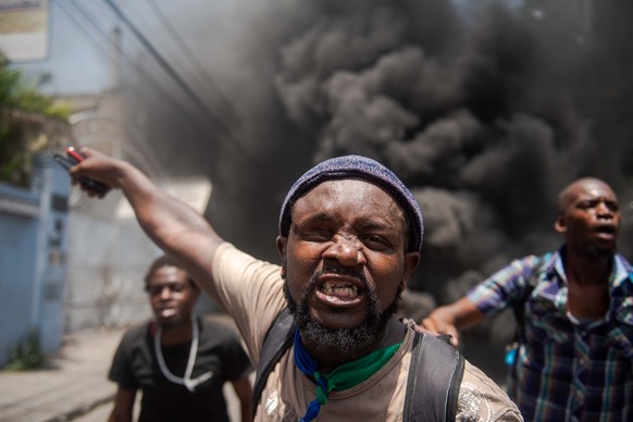 epa09210478 Demonsrators protest amid the celebration of the National Flag Day, in Port-au-Prince, Haiti, 18 May 2021. President of Haiti, Jovenel Moise, called on all the forces of the country to dia ...