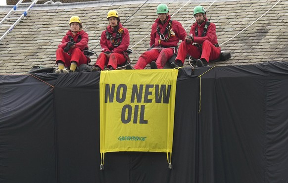Greenpeace activists sit on the roof of Britain&#039;s Prime Minister Rishi Sunak&#039;s house in Richmond, North Yorkshire, England, after covering it in black fabric, Thursday Aug. 3, 2023. Greenpea ...