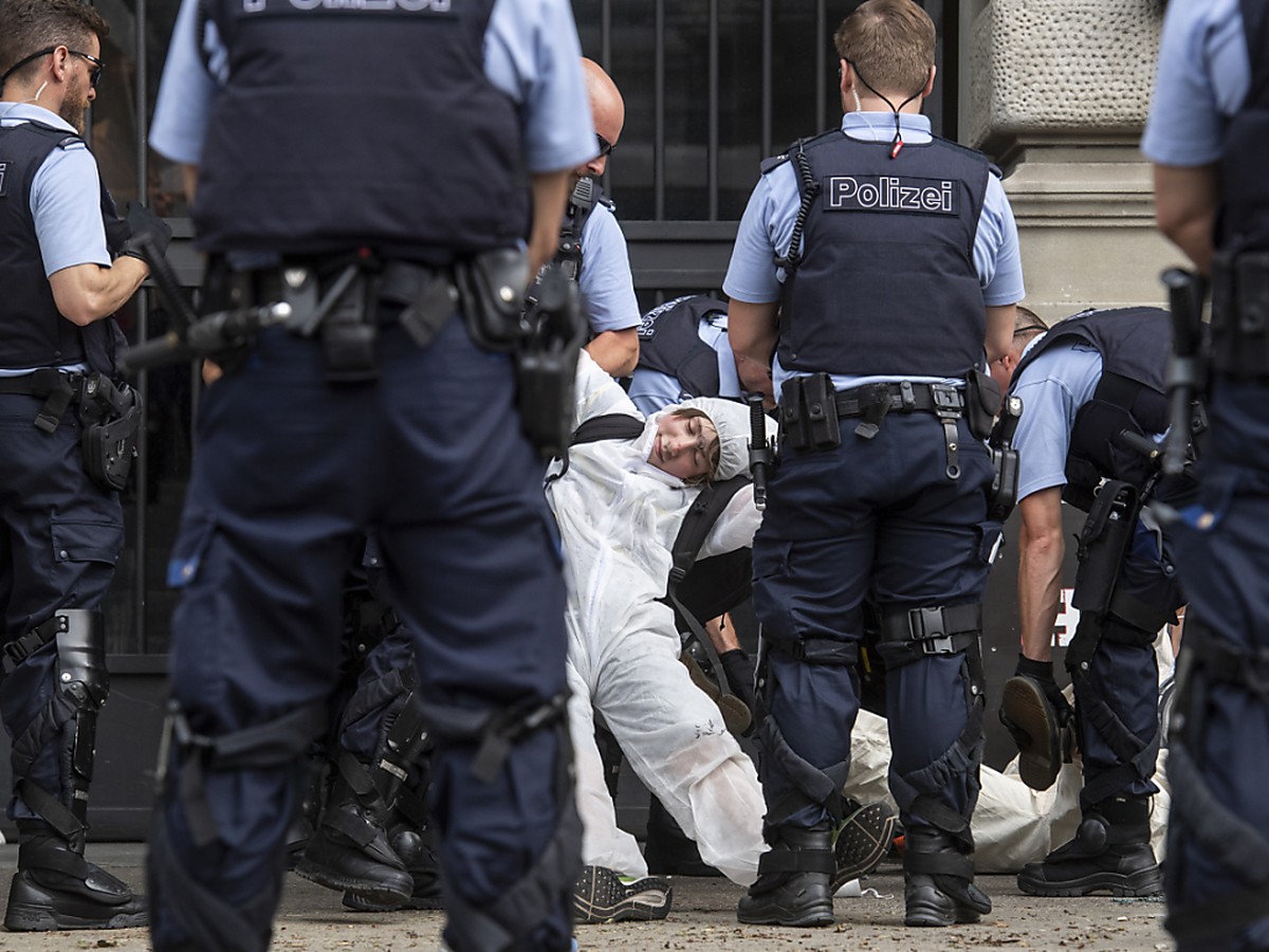 Polizisten führen die Klimaaktivisten der Organisation "Collective Climate Justice" am Eingang der Credit Suisse in Zürich ab.