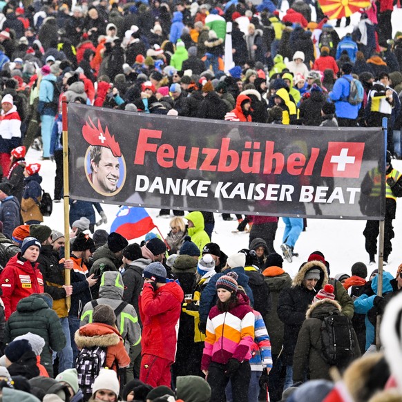 epa10419918 Fans of Switzerland's Beat Feuz cheer prior to the Men's Downhill race at the FIS Alpine Skiing World Cup at the Streif ski course in Kitzbuehel, Austria, 21 January 2023. EPA/JE ...