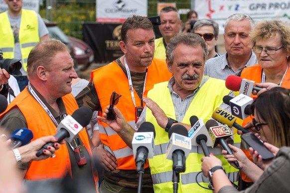 epa05489317 Andreas Richter (2-L) and Piotr Koper (L) and their spokesman Andrzej Gaik (3-R) speak to journalists near the site where they attempt to explore the existence of the so-called &#039;Nazi  ...