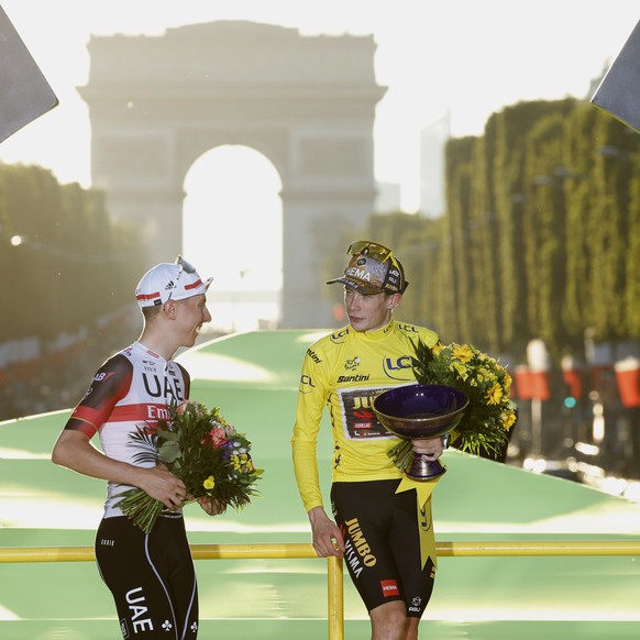 FILE - Tour de France winner Denmark&#039;s Jonas Vingegaard, wearing the overall leader&#039;s yellow jersey and Slovenia&#039;s Tadej Pogacar, wearing the best young rider&#039;s white jersey, leave ...