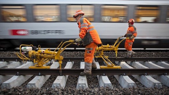 ZUM NACHHOLBEDARF BEIM UNTERHALT DES SBB-SCHIENENNETZES STELLEN WIR IHNEN FOLGENDES BILDMATERIAL ZUR VERFUEGUNG - Gleismonteure des Bauunternehmens Vanoli fixieren am fruehen Morgen des 10. Aprils 201 ...