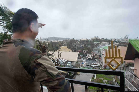 epa11778702 A handout photo made available by the French Army on 15 December 2024 shows a soldier at at an area overlooking damages in the French overseas territory of Mayotte. At least 14 people were ...