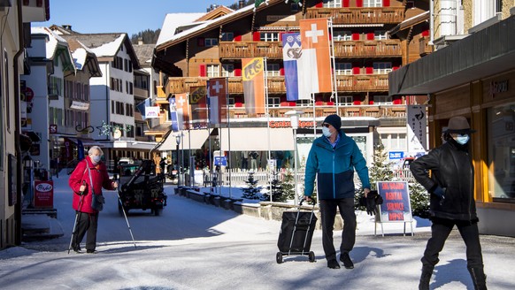 epa08931286 People wearing protective masks are walking down the street of the mountain village while preperations for the FIS Alpine Skiing World Cup in Wengen make progress amid the Coronavirus dise ...