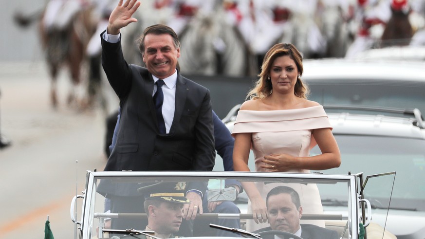 epa07257313 Brazilian President-elect Jair Bolsonaro (L) and wife Michele (R) head to the Planalto Palace on a Rolls Royce, for a ceremony in which Bolsonaro will receive the presidential band from hi ...