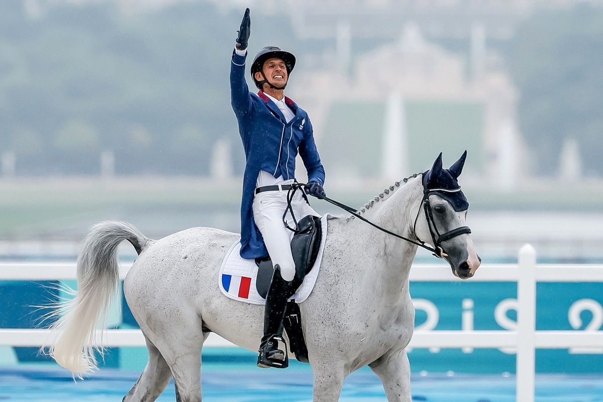 epa11499955 Stephane Landois of France gestures as he rides Chaman Dumontceau during the team and individual eventing of the Equestrian Dressage competitions in the Paris 2024 Olympic Games, at the Ch ...