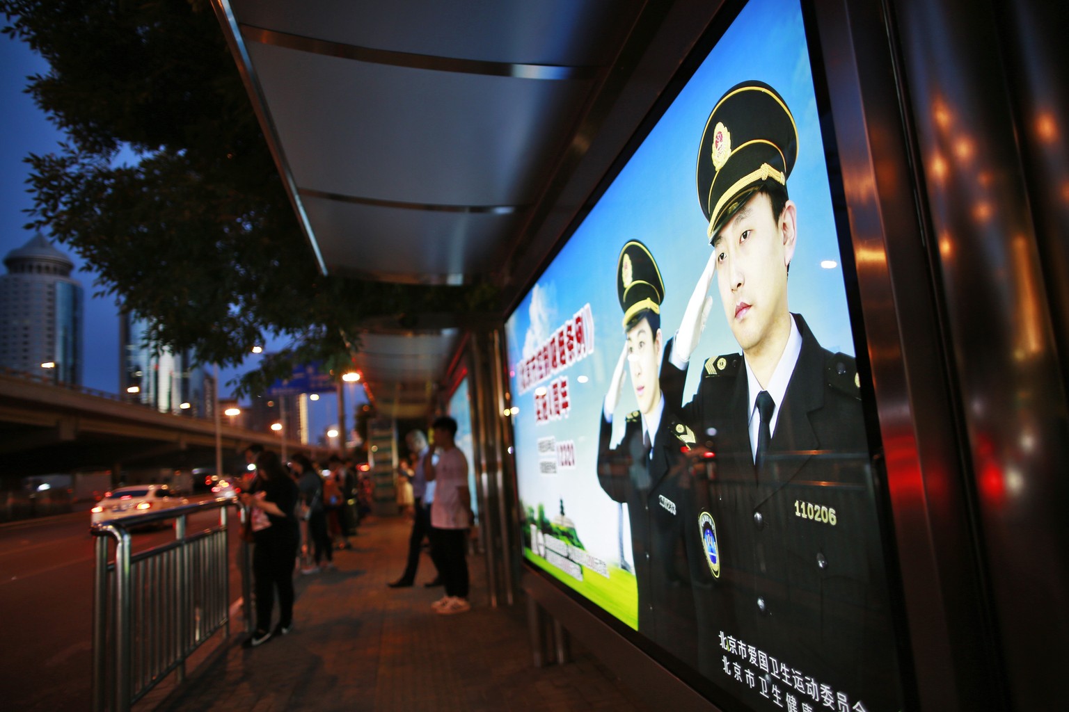 epa07621602 A poster of police officers saluting are seen at a bust stop in the Central Business District (CBD) of Beijing, China, 27 May 2019 (issued 03 June 2019). This year, 04 June 2019 marks the  ...