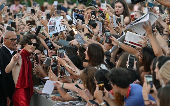 epa10155259 US actor Timothee Chalamet (L) signs autographs as he arrives for the premiere of &#039;Bones and All&#039; during the 79th annual Venice International Film Festival, in Venice, Italy, 02  ...