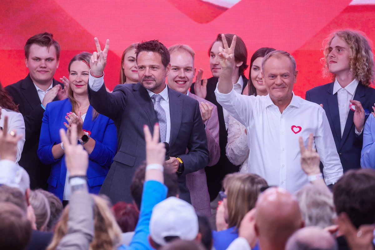 epa11400807 Polish Prime Minister Donald Tusk (R) and Warsaw Mayor Rafal Trzaskowski (C) gesture the V-sign at the Civic Coalition's election headquarters in Warsaw, Poland, 09 June 2024. EPA/LES ...
