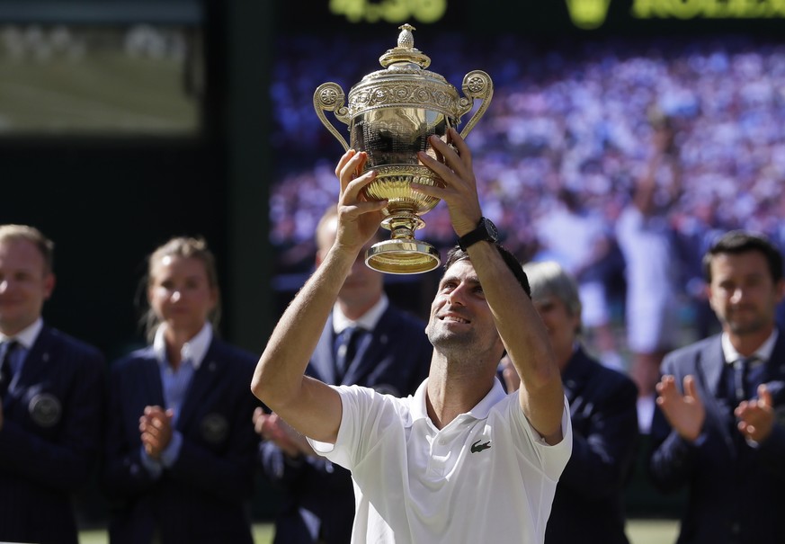 Serbia&#039;s Novak Djokovic lifts the trophy after winning the men&#039;s singles final match against Kevin Anderson of South Africa, at the Wimbledon Tennis Championships, in London, Sunday July 15, ...