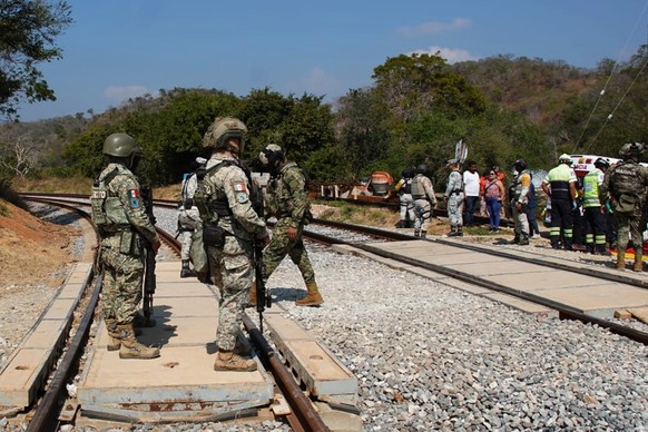 epa12616471 Members of the Mexican Navy monitor an area after after the Transistmico train derailed in the municipality of Asuncion Ixtaltepec in Oaxaca, Mexico, 28 December 2025. At least 13 people d ...