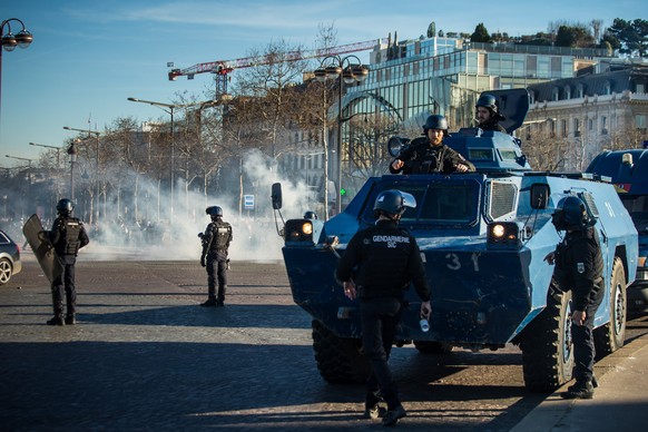 epa09750517 French police throws teargas on the Champs Elysees as participants in a so-called &#039;Freedom Convoy&#039; are trying to block the traffic, in Paris, France, 12 February 2022. Paris poli ...