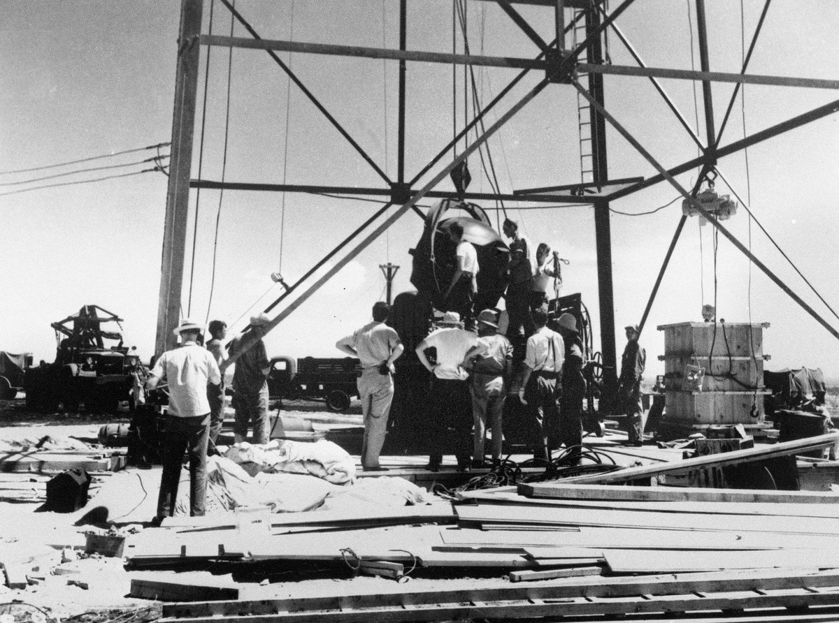 FILE - Scientists and other workers rig the world's first atomic bomb to raise it up onto a 100-foot tower at the Trinity Test Site near Alamagordo, N.M. A new film on J. Robert Oppenheimer' ...