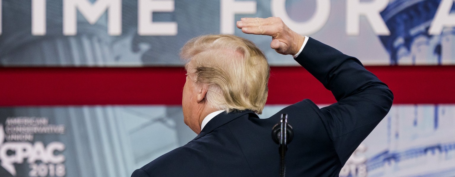 epa06558395 US President Donald J. Trump pretends to fix his hair as he addresses the 45th annual Conservative Political Action Conference (CPAC) at the Gaylord National Resort &amp; Convention Center ...