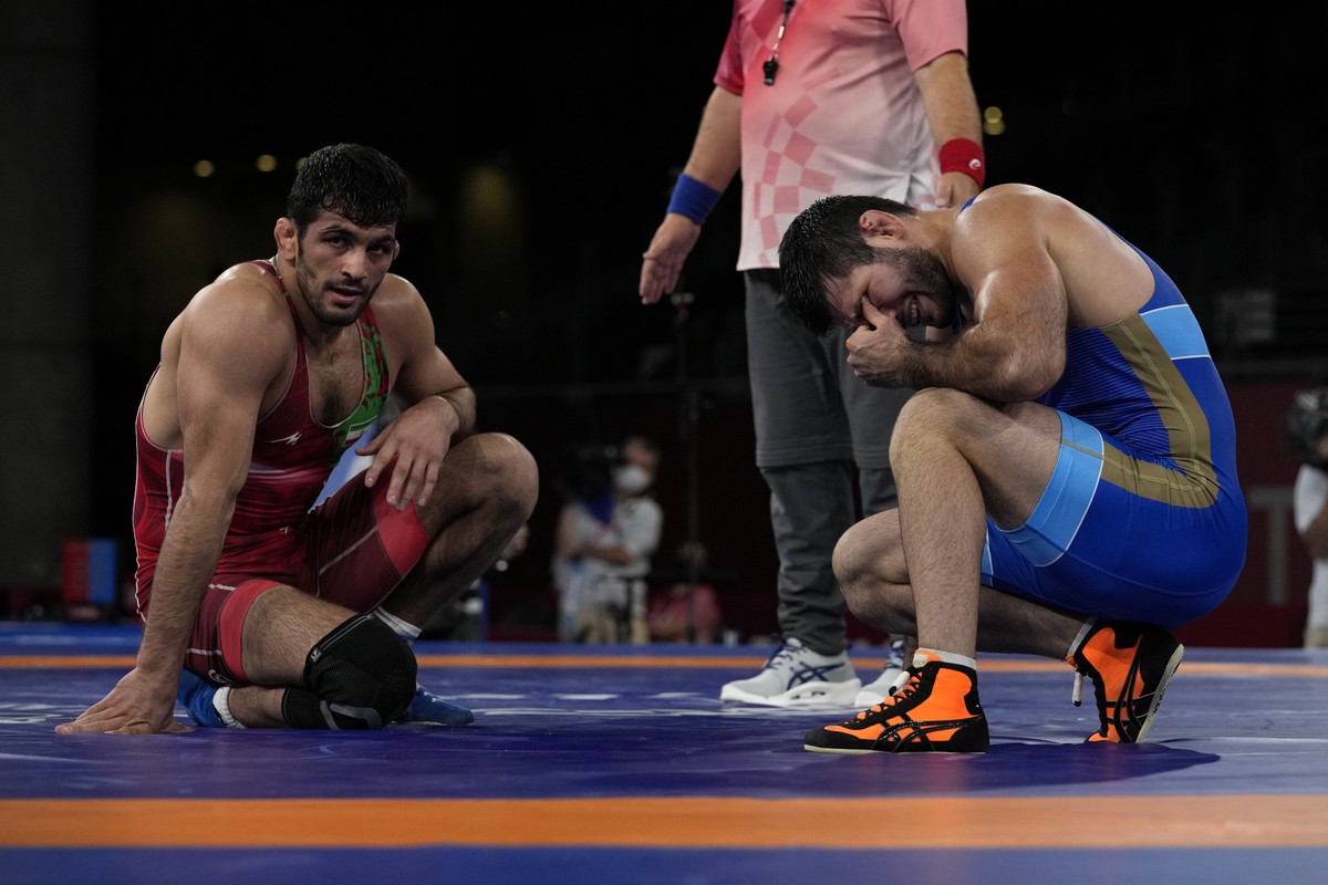 Russian Olympic Coomittee'a Artur Naifonov, right, reacts as he lost against Iran's Hassan Yazdanicharati, left, as compete in the men's 86kg Freestyle semifinal wrestling match at the  ...