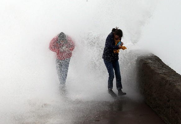 People escape a wave from the Atlantic Ocean, in Biarritz, southwestern France, Sunday, Dec.22, 2019. Most of the French regions are on alert for violent storms and high winds. (AP Photo/Bob Edme)