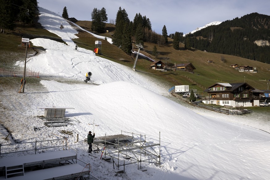 A snow canon and a pile of artificial snow are photographed close to the finish Area under construction of the the Alpine Skiing FIS Ski World Cup, at Adelboden, Switzerland, Wednesday, December 28, 2 ...