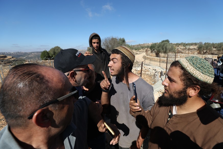 KEYPIX - epa12489604 Israeli settlers confront Palestinian farmers and international activists harvesting olives at a farm outside the village of Yabroud and close to an Israeli settler outpost, near  ...